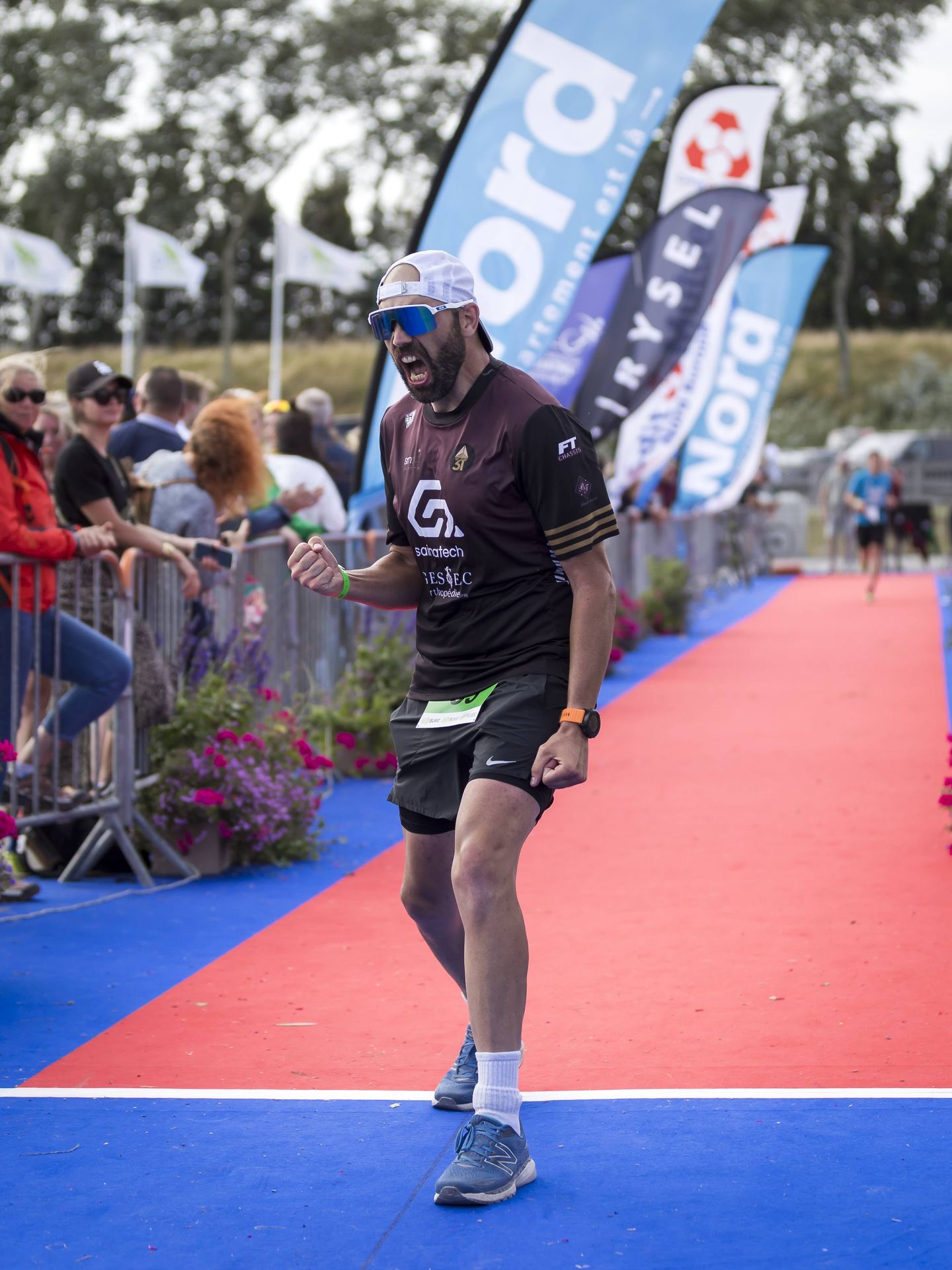 Ironman terminé – Un moment gravé à jamais Derniers mètres du Full Ironman, criant toute ma rage et mon soulagement en franchissant la ligne d’arrivée. Un mélange de douleur, d’émotions et de fierté après cet exploit.
