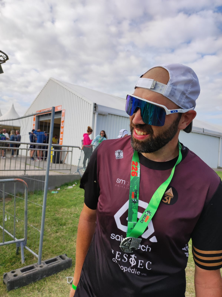 Finisher – Une victoire sur soi-même Finisher du Full Ironman, médaille autour du cou, affichant un large sourire. Après des mois de préparation et une course éprouvante, la satisfaction d’avoir franchi la ligne d’arrivée est indescriptible.