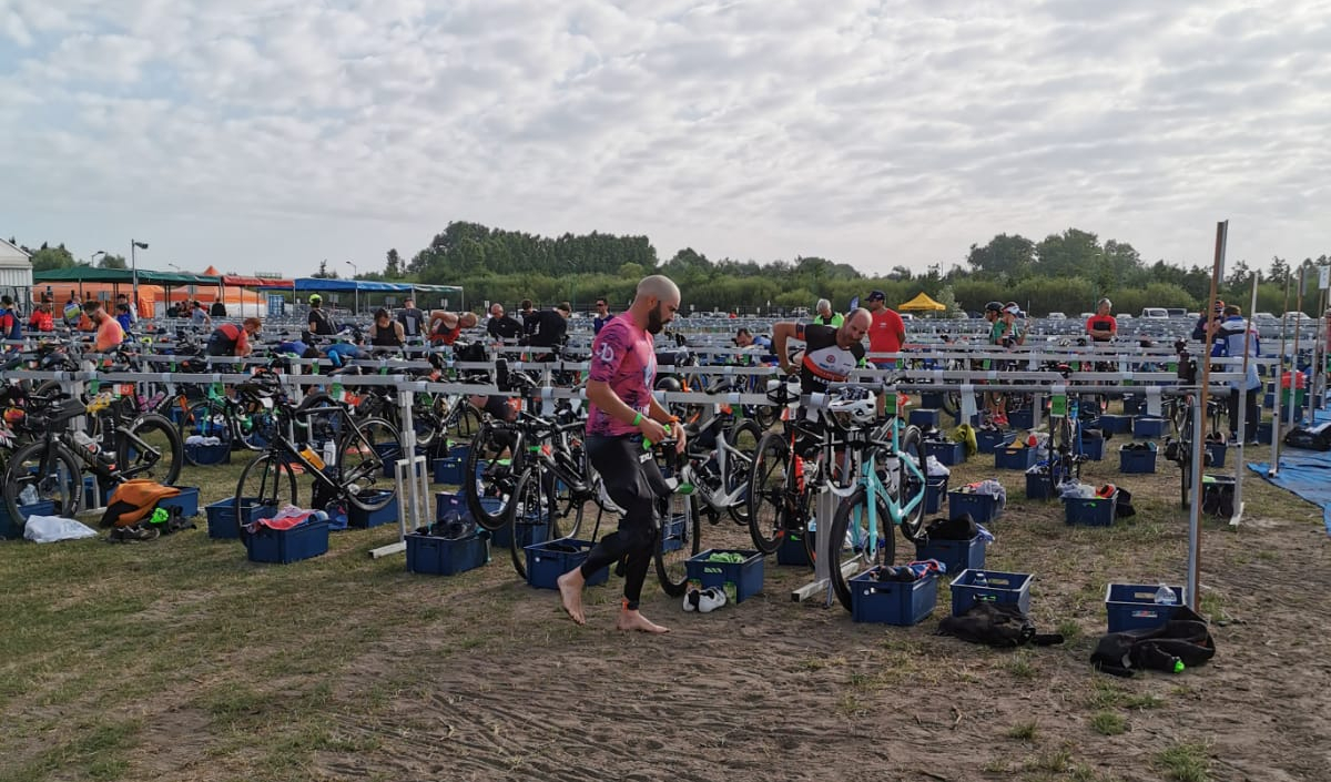 Moment clé en transition 1, en pleine préparation pour entamer les 180 km de vélo. Changement rapide de tenue et vérification du matériel avant le départ.