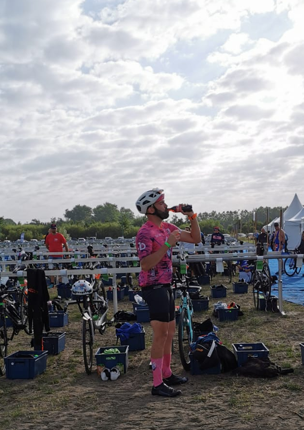Juste avant d’enfourcher le vélo pour 180 km, un dernier ravitaillement rapide avec une gorgée de Coca pour un coup de boost. Casque et chaussures déjà en place, prêt à attaquer la route.