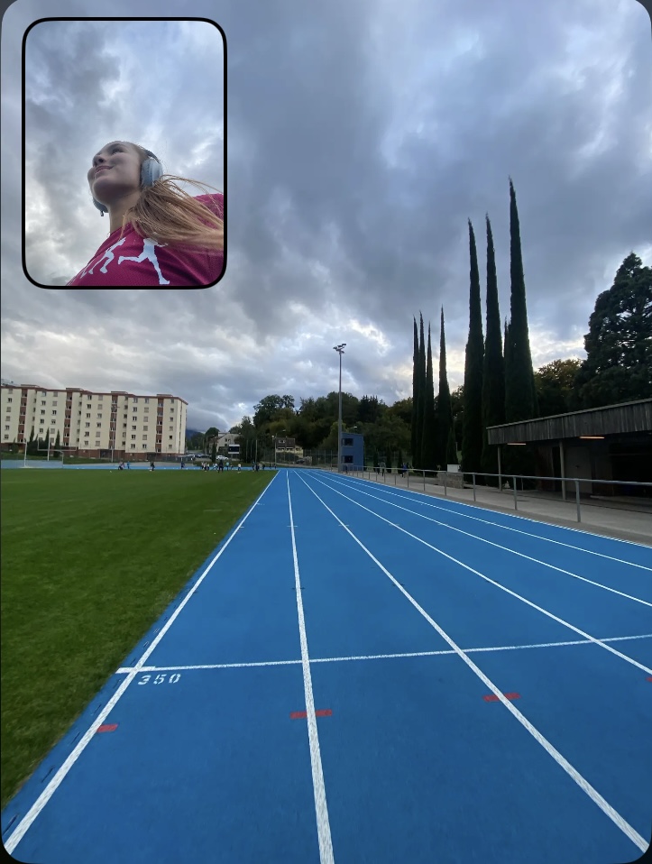 Entraînement intense – La régularité, clé de la progression Toscane en pleine séance sur une piste d’athlétisme bleue, concentrée sur son effort, casque de musique sur les oreilles. Chaque entraînement compte sur la route du semi-marathon !