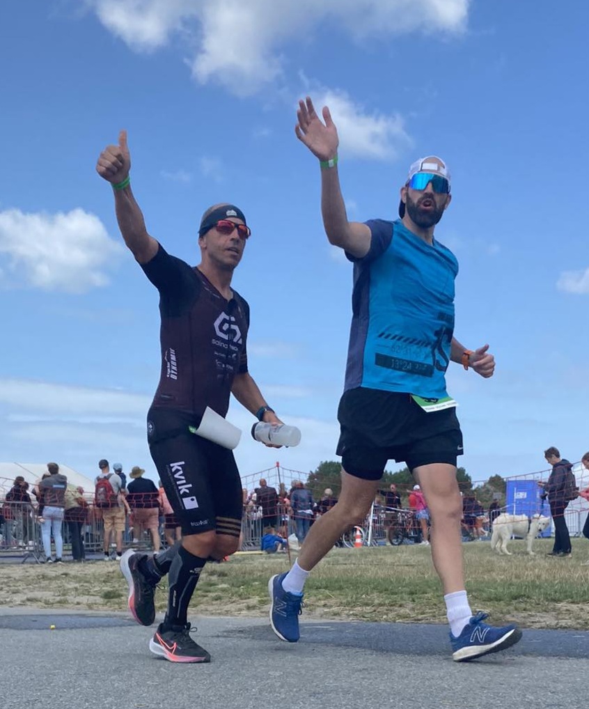 Quand le mental prend le relais, chaque encouragement compte Malgré les kilomètres accumulés, l’énergie est toujours là ! Avec Jean, nous saluons le public lors du marathon de mon premier Full Ironman. Un moment de partage unique.