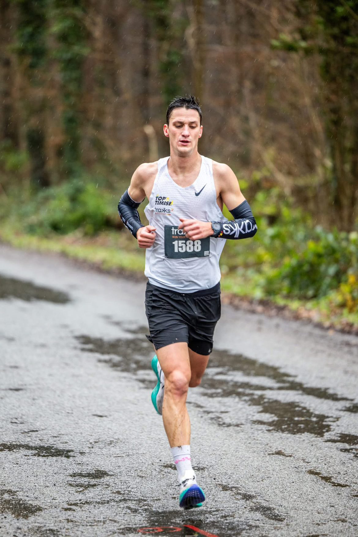 S’équiper pour performer, quelles que soient les conditions Louis concentré lors de la Corrida de Gerpinnes, sous une pluie battante. Vêtu d’un singlet blanc et de manchettes, il montre l'importance d'une tenue respirante et adaptée aux conditions météorologiques.