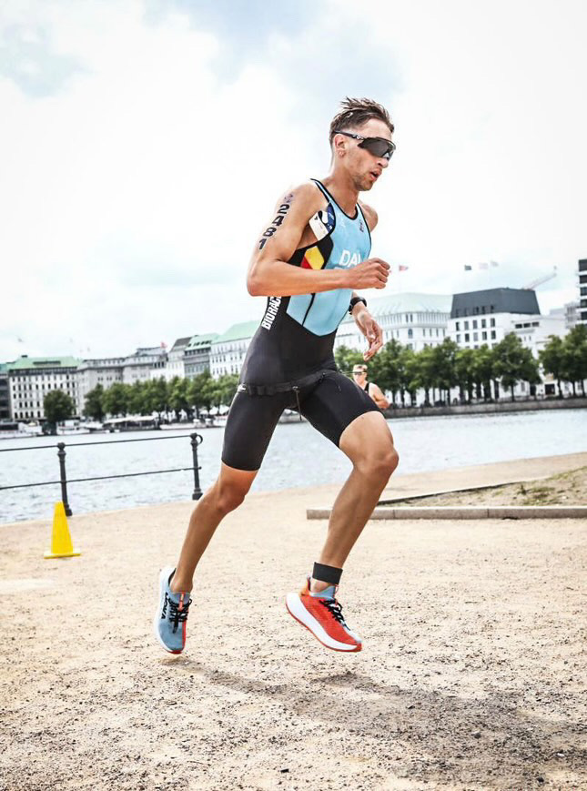 Le bon équipement fait la différence en course comme en compétition Lucas, ultra concentré en pleine course lors d’un triathlon au championnat du monde. Habillé d’une trifonction aux couleurs de la Belgique et de lunettes de soleil, il illustre l'importance d'un équipement performant en compétition.