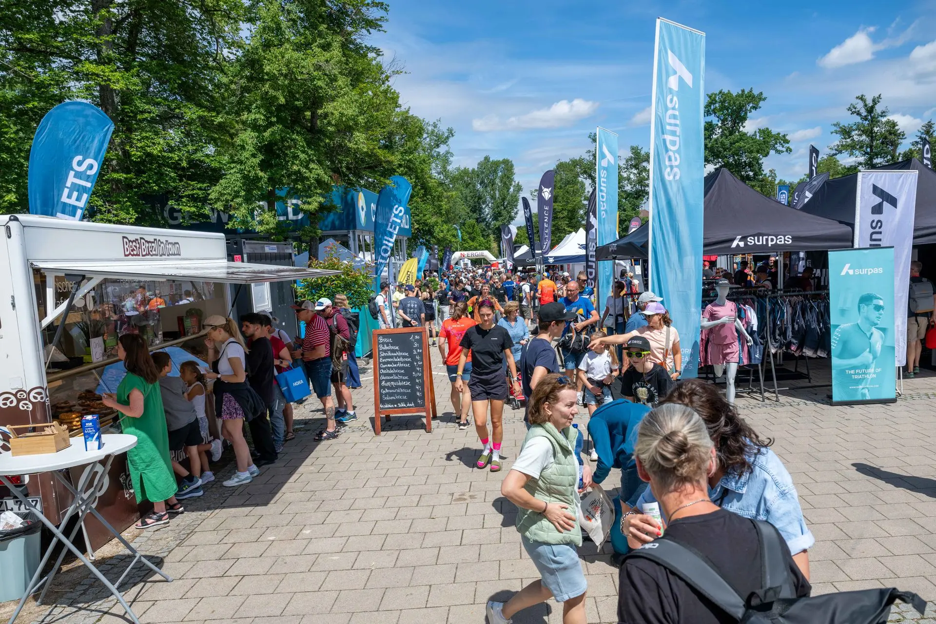 Une immersion dans l’ambiance du village triathlon de Roth, où l’on croise athlètes et supporters au milieu des stands spécialisés.