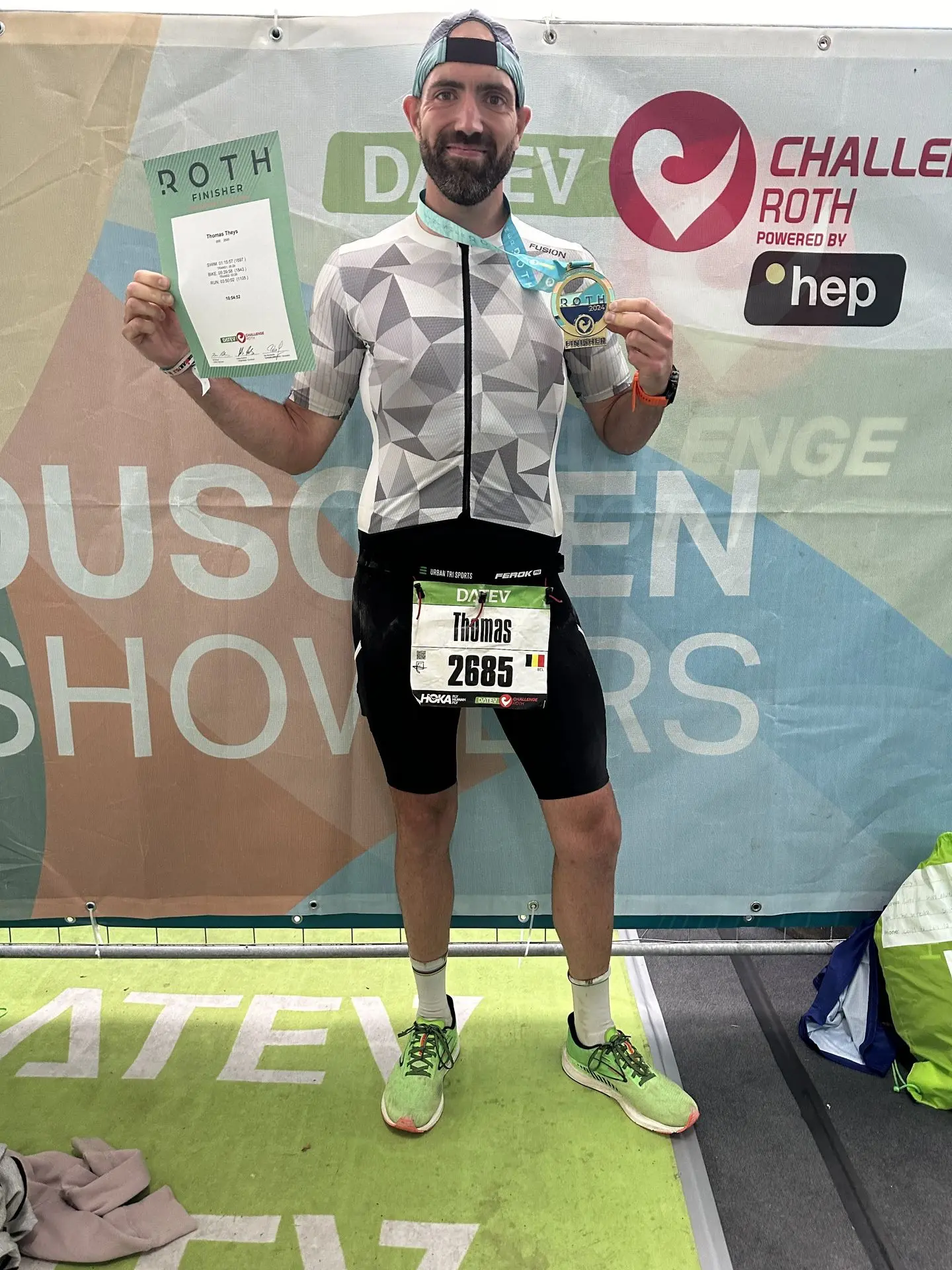 Un finisher comblé, souvenir d’un exploit gravé à jamais. Fier et heureux, arborant ma médaille et mon diplôme avec mes temps de passage. Un sourire immense, la trifonction blanche Fusion marquée par l’effort.