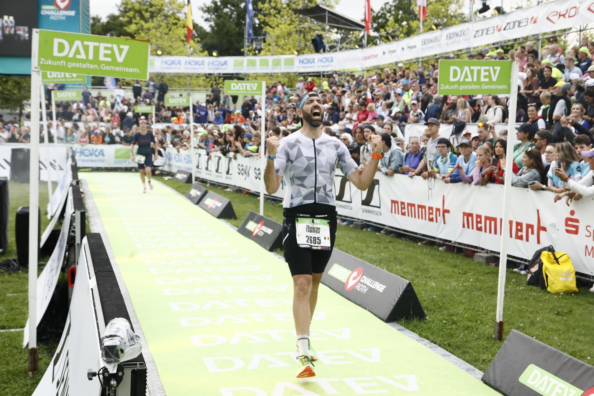 Victoire personnelle : l’émotion brute à l’arrivée du Full Ironman de Roth ! Moment intense d’un athlète franchissant la ligne d’arrivée du Full Ironman de Roth, en Allemagne, criant de joie après des heures d’effort et de dépassement de soi. Un instant de pure émotion et d’accomplissement.