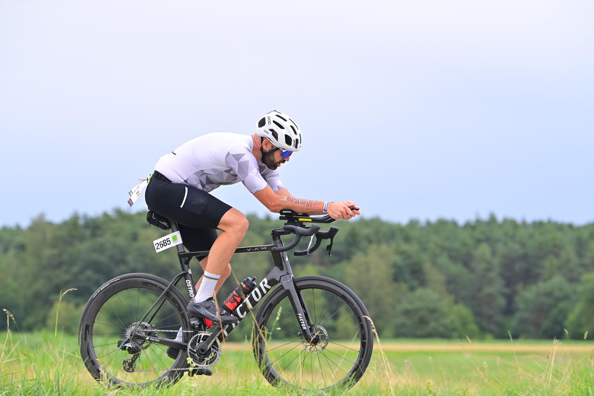 Concentration absolue sur la route. Chaque coup de pédale rapproche de l'objectif. Athlète en pleine course lors de son second Full Ironman à Roth, en Allemagne. Positionné sur les prolongateurs, regard fixé sur la route, illustrant la concentration et la détermination en pleine épreuve d’endurance.